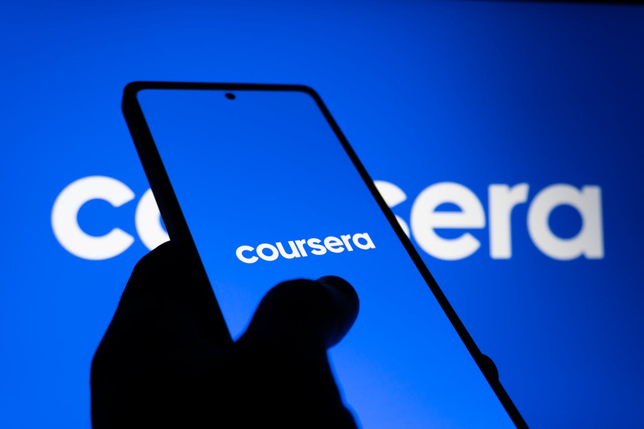 A smartphone displaying the Coursera logo against a bright blue background, symbolizing online learning.